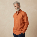 Man wearing an orange hemp shirt against a beige background