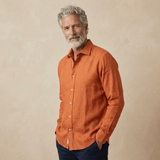 Man wearing an orange hemp shirt against a beige background