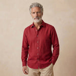65 year old male model wearing red shirt of beautifully soft 100% hemp fabric against a beige background. 