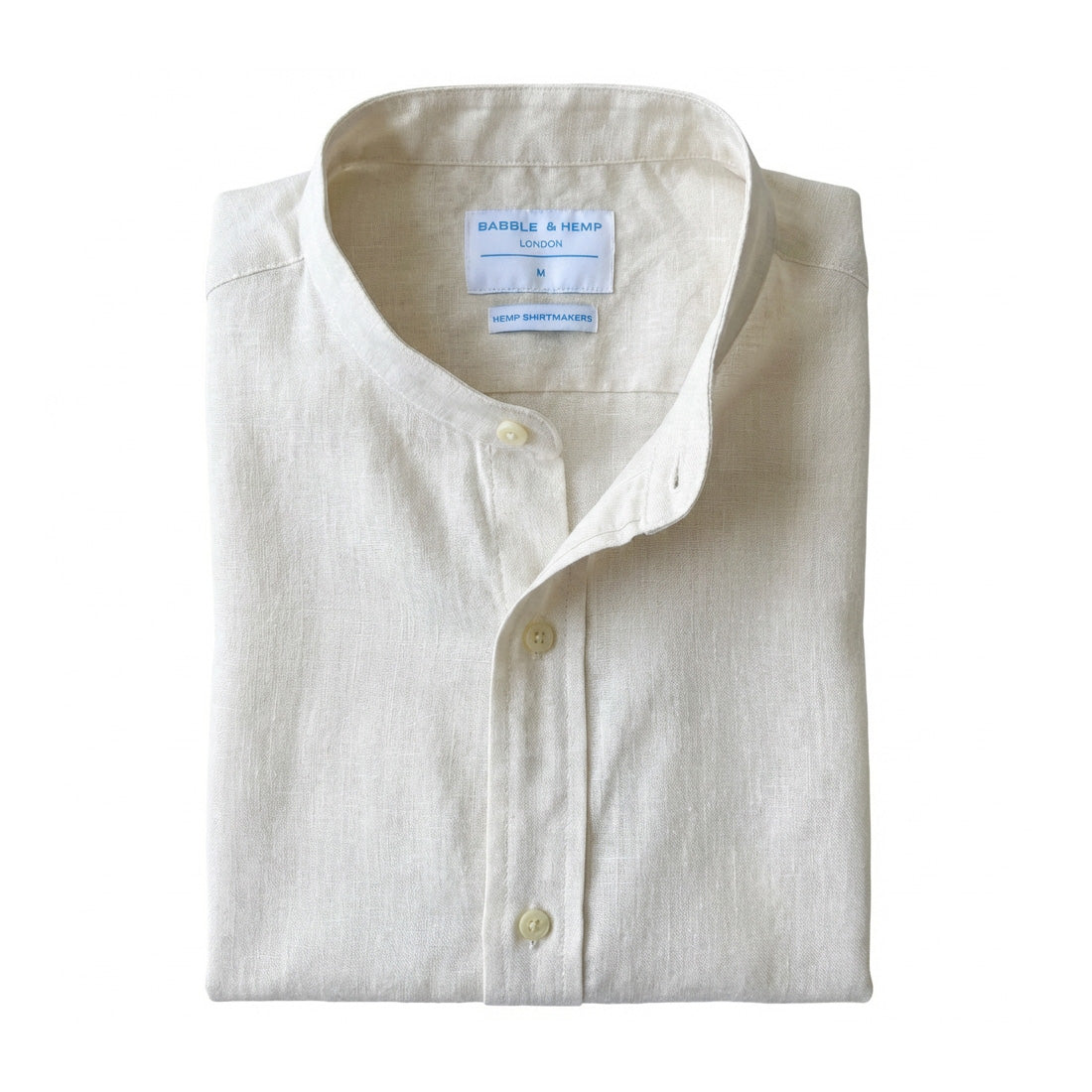 Folded white hemp grandad collar shirt with a visible label on a white background