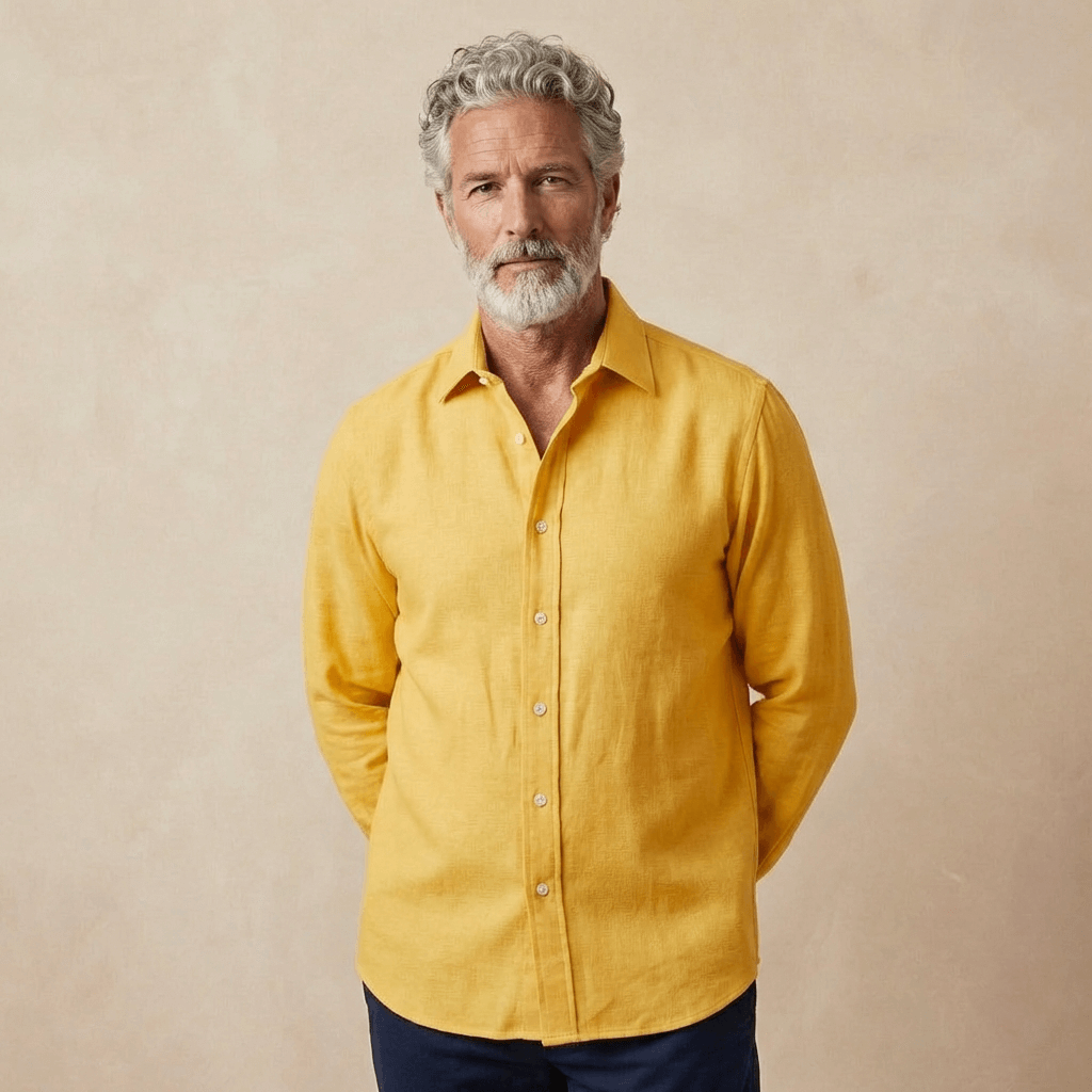 man wears yellow hemp shirt in heavy weight of fabric in front of beige backdrop