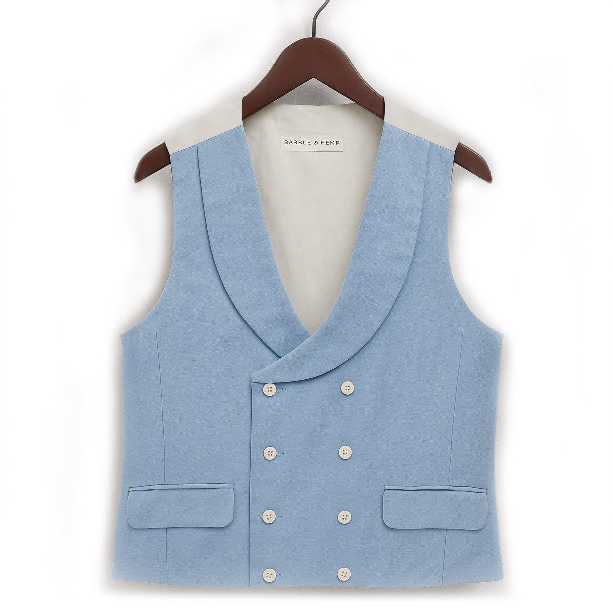 light blue hemp waistcoat on hanger with white shell buttons against white backdrop 