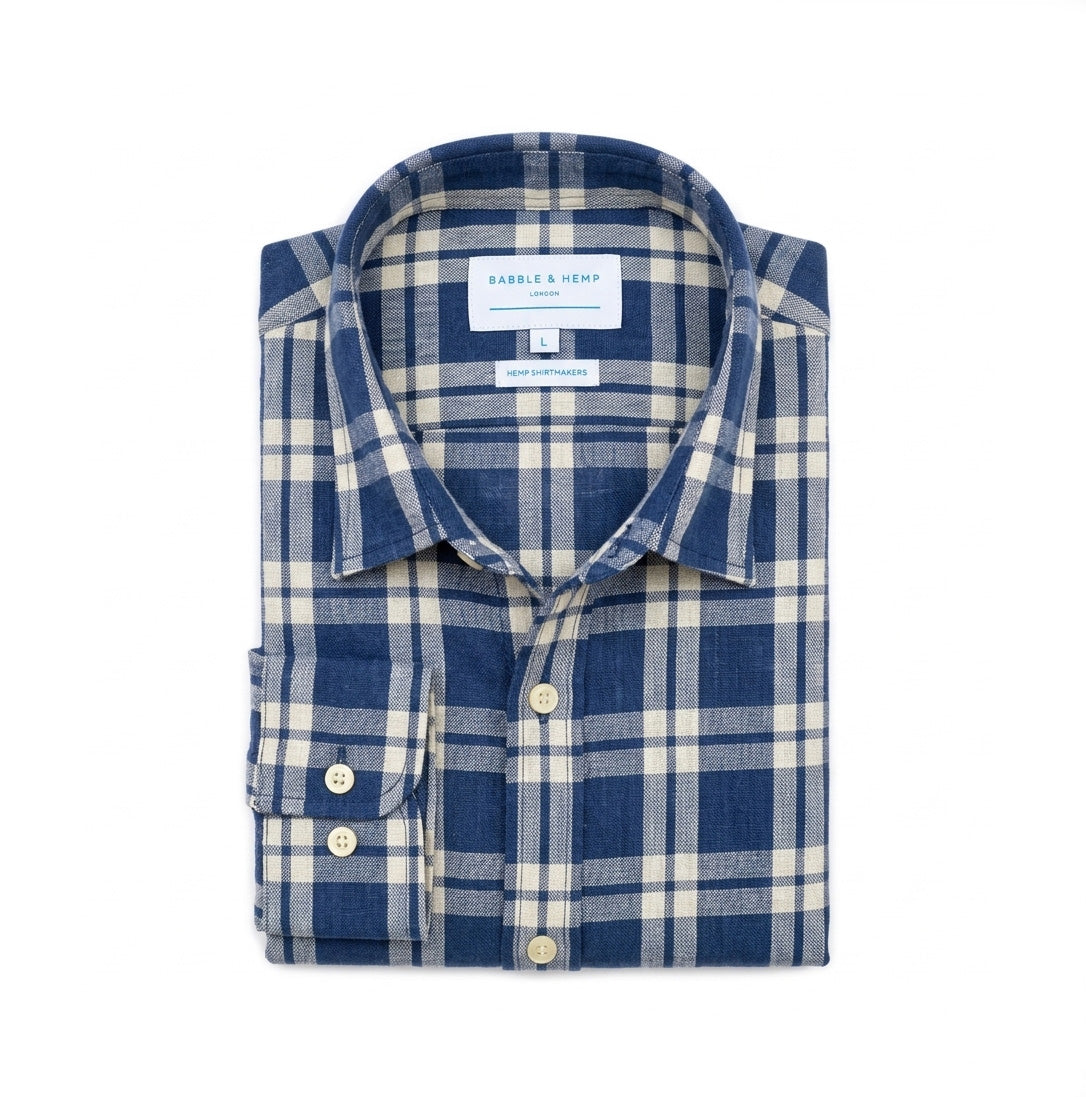 A folded long-sleeve plaid hemp shirt by Babble & Hemp London, featuring a blue and off-white check pattern, shown on a solid white background.