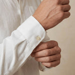 closeup shot of the cuff and button being fastened on a hemp shirt with pocket colour white