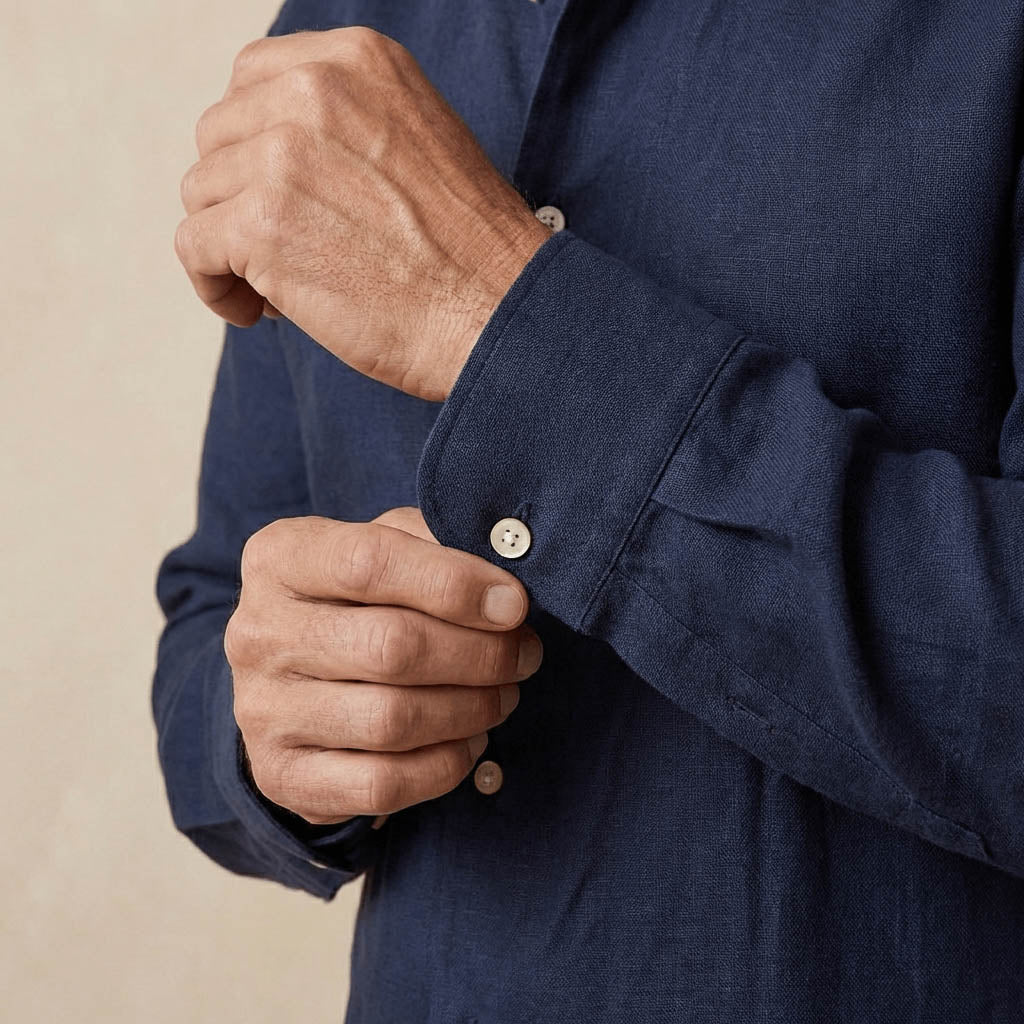 closeup shot of the cuff and button  being fastened on a hemp shirt colour navy blue