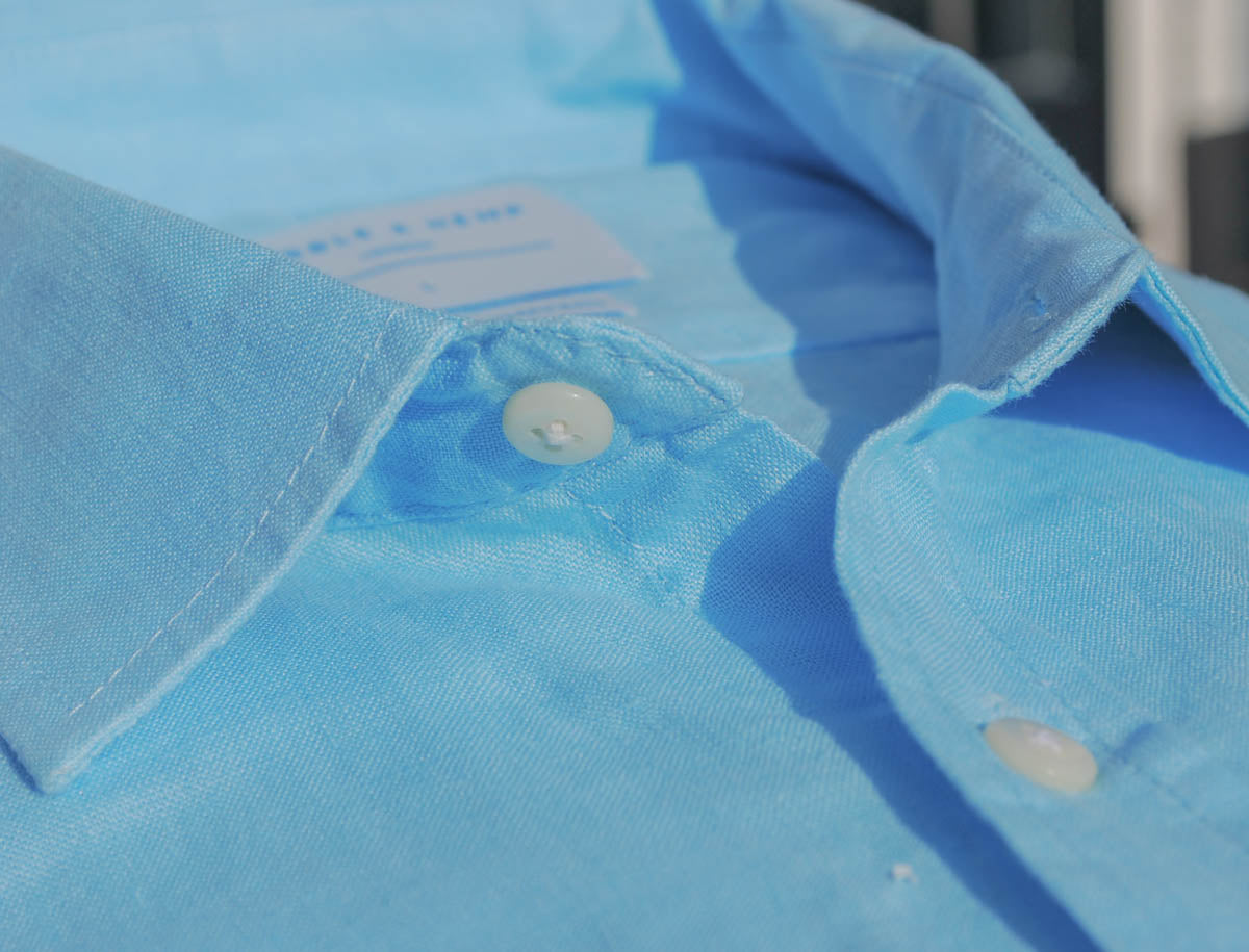 Close-up of a blue shirt collar with buttons