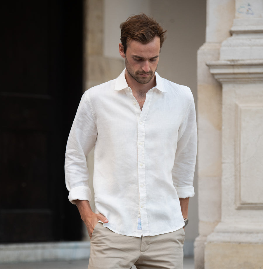 a man walks down steps whilst wearing a white hemp shirt