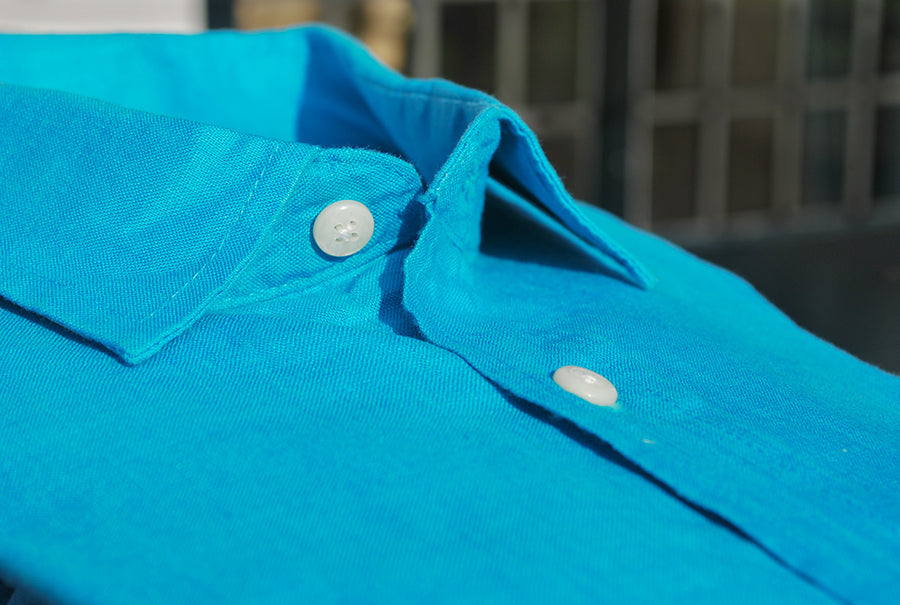 a closeup image of a blue hemp shirt collar and buttons