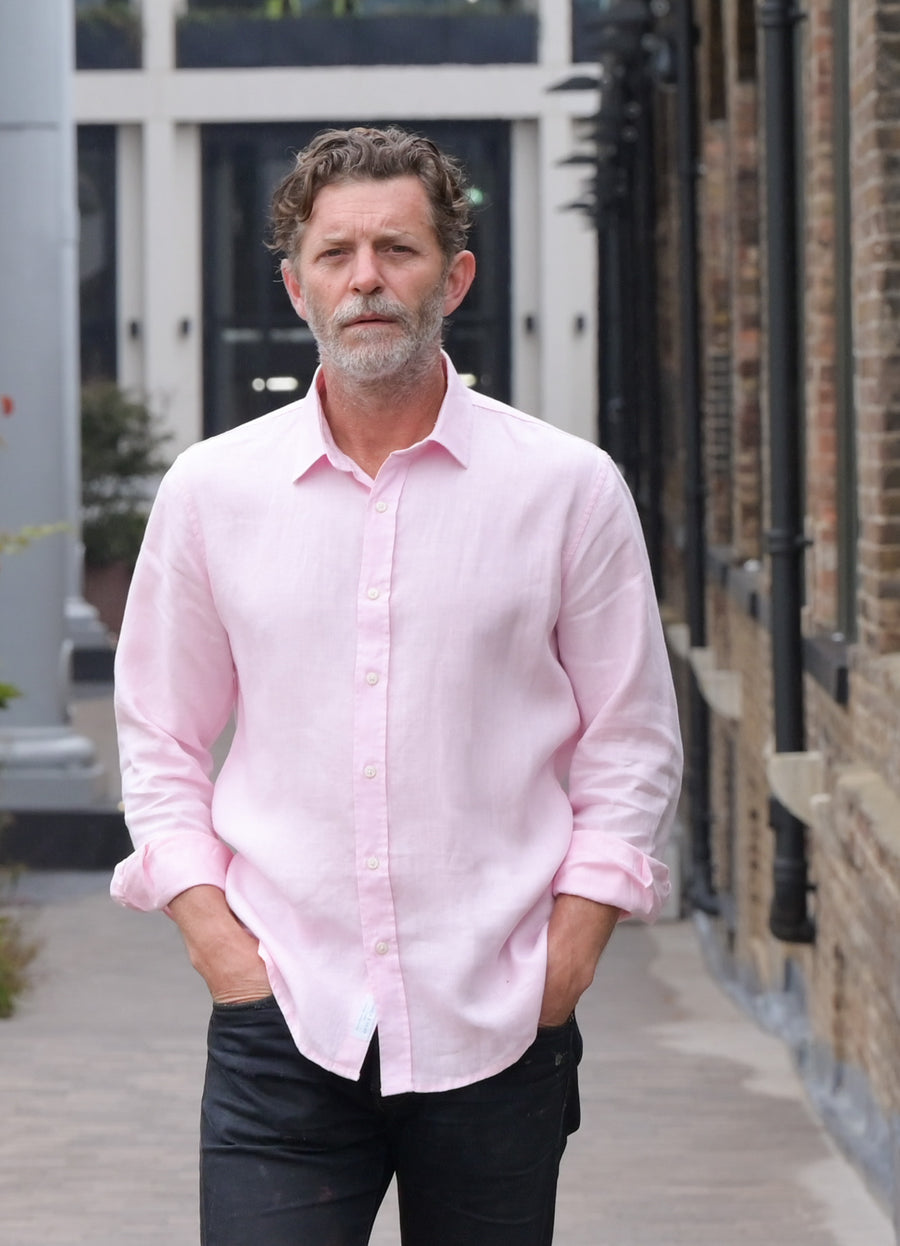 a man wears a pink hemp shirt with his hands in pockets