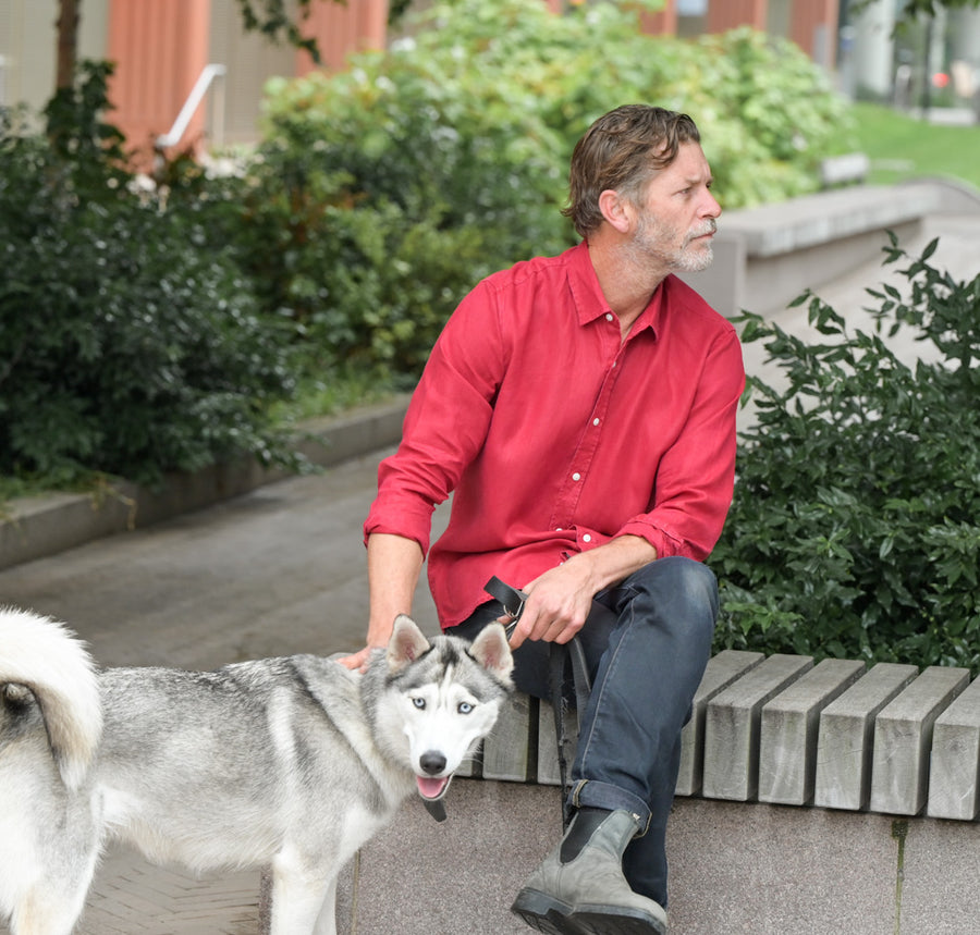 a man sitting on a bench wearing a sustainable shirt 