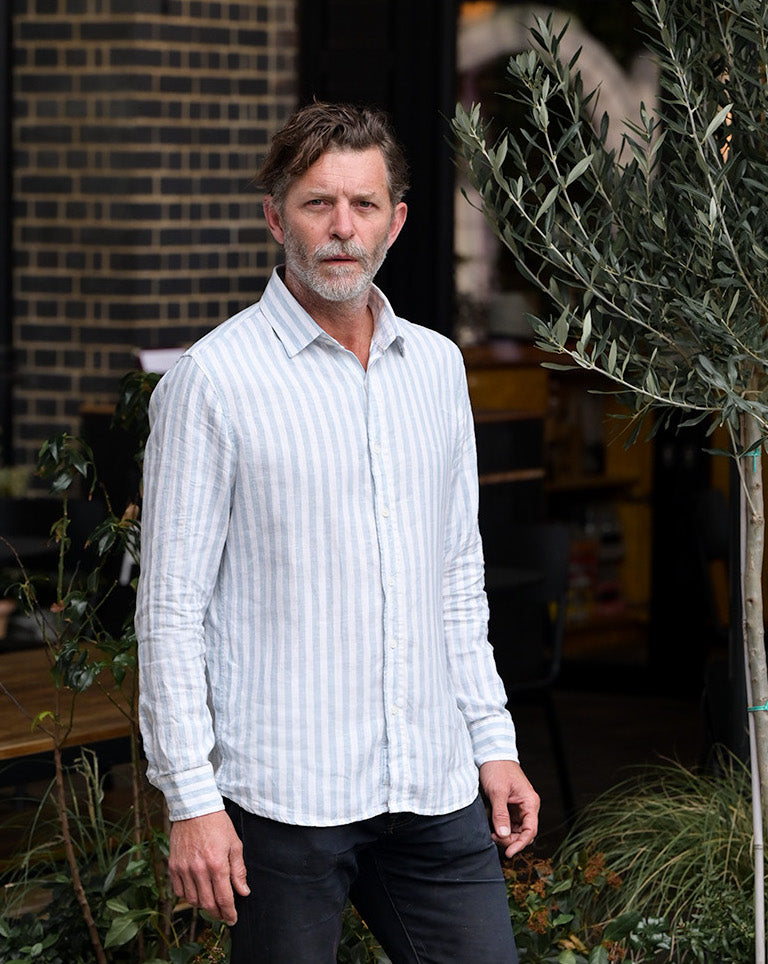 a male model wears our blue and white striped hemp shirt