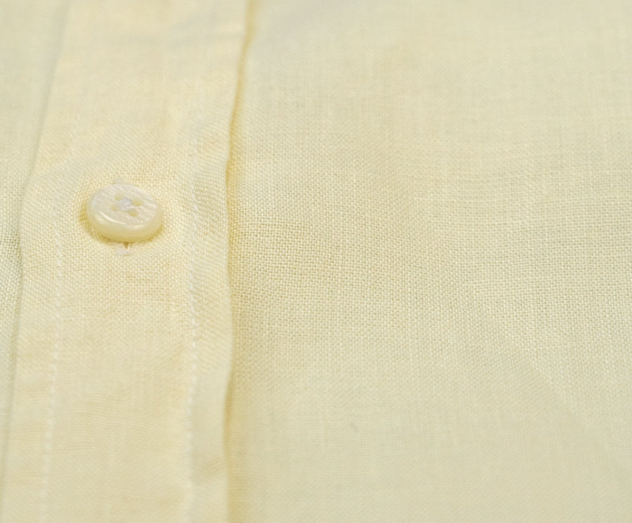 a close up detail image of a yellow hemp shirt and the buttons